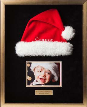Shadowbox with Santa had and picture of child wearing hat commemorating childs first Christmas.