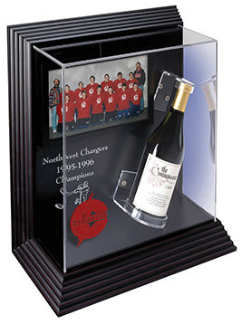 Acrylic case displaying a team picture and a bottle of champagne