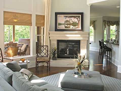 Photograph of nicely decorated living space with a large custom framed landscape over the fireplace.