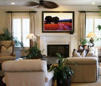 Living room design with furniture and beautiful piece of art hanging over fireplace.