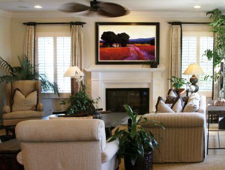 Living room design with furniture and beautiful piece of art hanging over fireplace.