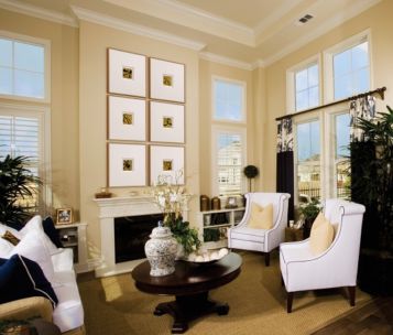 Traditional room setting with multiple framed pieces over a fireplace.