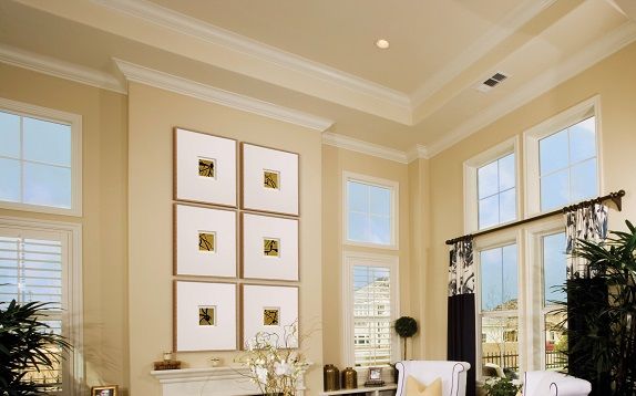 Traditional room setting with multiple framed pieces over a fireplace.