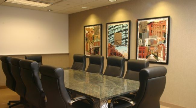 Conference room with conference table, chairs and beautifully framed custom artwork.