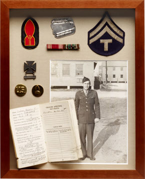 Shadowbox frame with various pieces of military memorabilia.