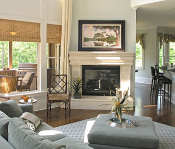 Photograph of nicely decorated living space with a large custom framed landscape over the fireplace.
