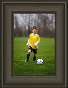 Custom framed picture of young soccer player about to kick a soccer ball.