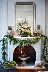 Fireplace with custom framed mirror above beautifully decorated for holiday season.