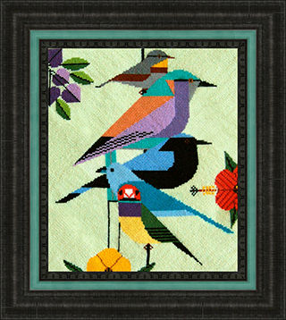 Framed needle art showing abstract birds nesting with flowers.